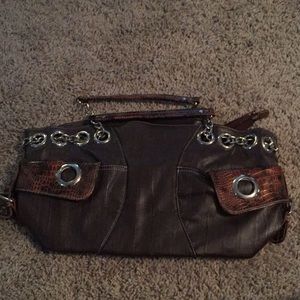 Brown handbag with gator handle and pockets.